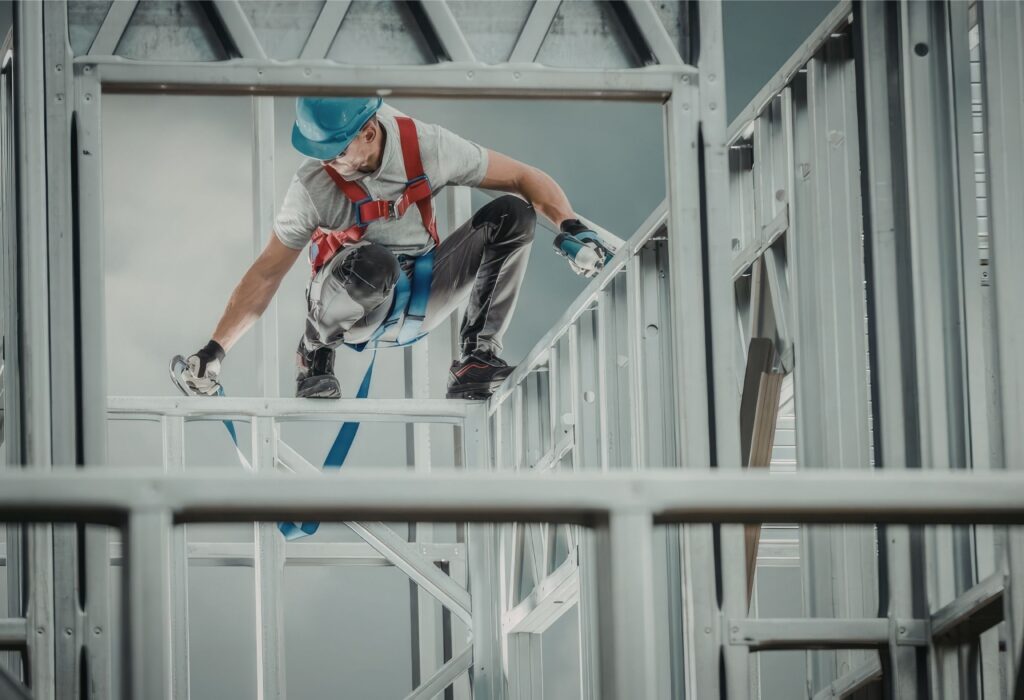 A construction worker safely standing on an aluminium mobile scaffold, representing the average cost of renting mobile scaffolding for a week.